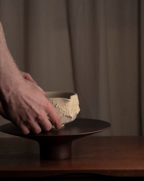 Eine Matcha Bowl wird auf einen Holzständer gestellt